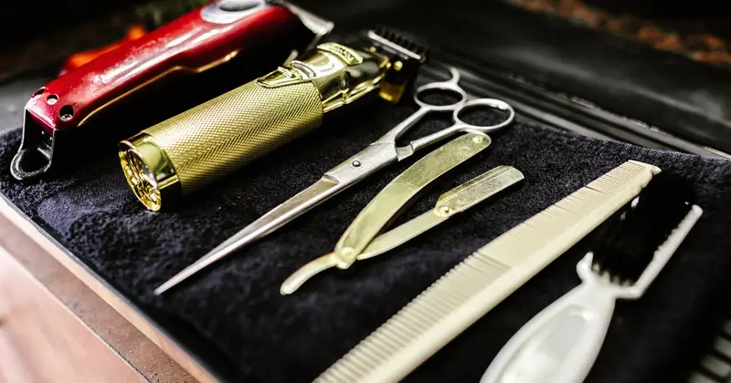 A collection of essential barbershop tools including trimmers, scissors, and razors neatly arranged.